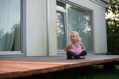 Full length of girl sitting on porch