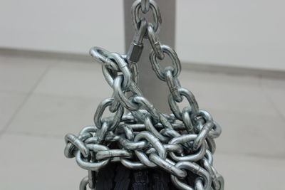 Close-up of chain hanging against wall