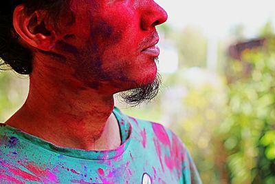 Midsection of man face covered with powder paint during holi