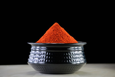 Close-up of orange juice on table against black background