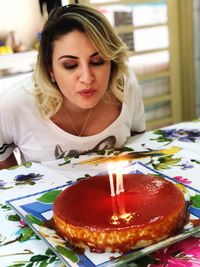 Woman blowing candles on cake during birthday
