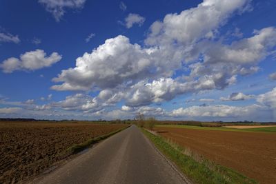 Empty road against cloudy sky