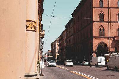 Cars on road by buildings in city