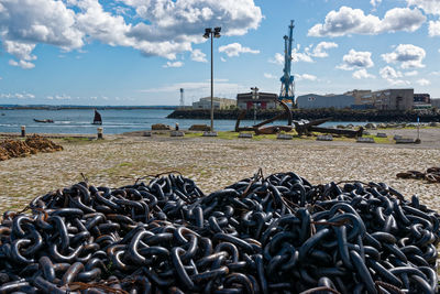 Close-up of chains on beach against sky
