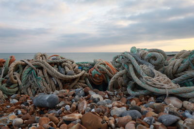 Rocks by sea against sky during sunset