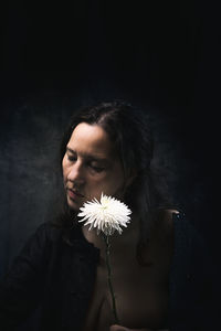 Woman in melancholic attitude with white chrysanthemum iii