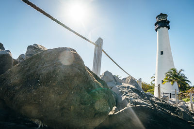 Low angle view of lighthouse amidst buildings against sky