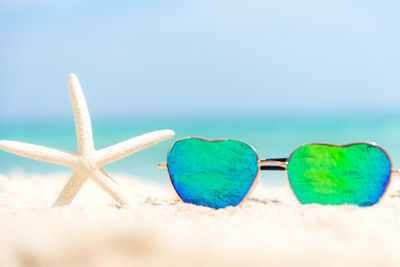 Close-up of sunglasses on beach