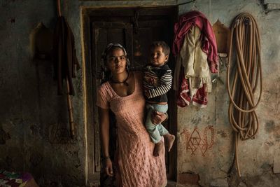 Young woman standing against wall