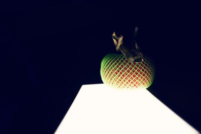 Close-up of illuminated lamp on table against black background