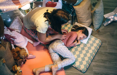 High angle view of woman sitting on bed at home