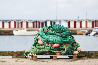 Close-up of fishing net on pier against sky