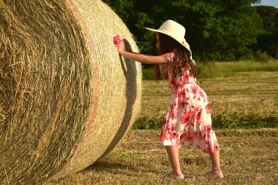 Rear view of woman standing on hay