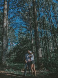 Young couple standing on land in forest