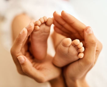 Cropped image of baby on bed