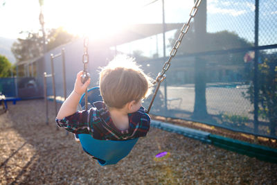  outdoor plastic playing area for children. little boy on swing and slide.