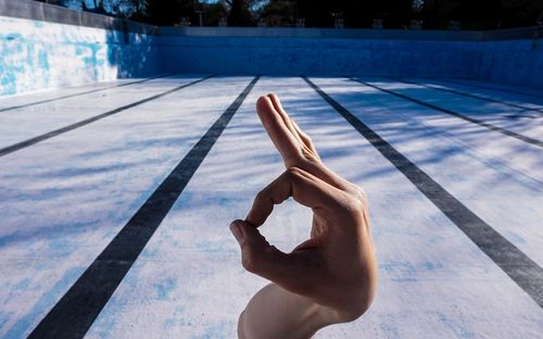 Cropped hand of person gesturing ok sign outdoors