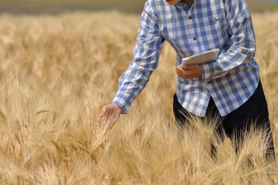 Midsection of person standing in wheat field