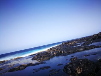 Scenic view of sea against clear blue sky