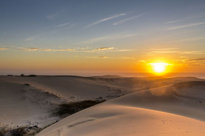 Scenic view of beach against sky during sunset