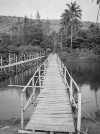 Empty wooden footbridge over river