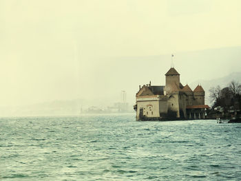 Building by sea against sky