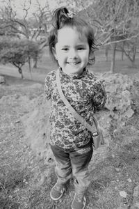 Portrait of girl smiling while standing on field