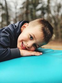 Portrait of a little kid lying down at the park