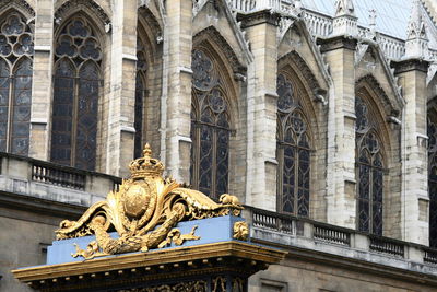Low angle view of gold ornate against historic building