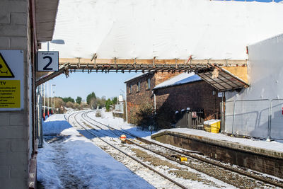 Railroad tracks amidst buildings during winter