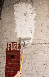 Cropped image of hand painting wall with paint roller