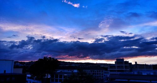 Buildings against cloudy sky at sunset