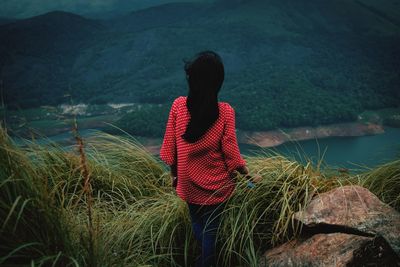 Rear view of woman standing on mountain