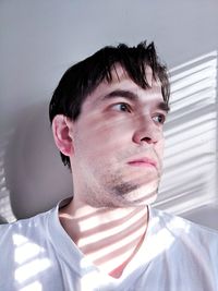 Portrait of young man against wall at home