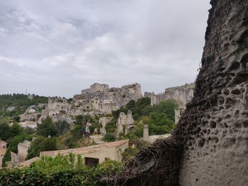 Old buildings in city against cloudy sky