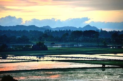 Scenic view of lake against sky during sunset