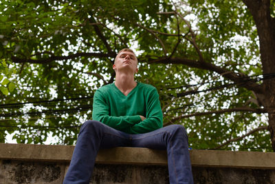 Man sitting on bench against trees