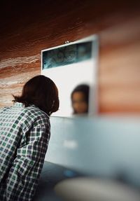 Rear view of boy standing in bus