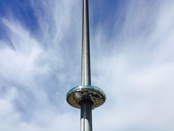 Low angle view of tower at amusement park against cloudy sky during sunny day