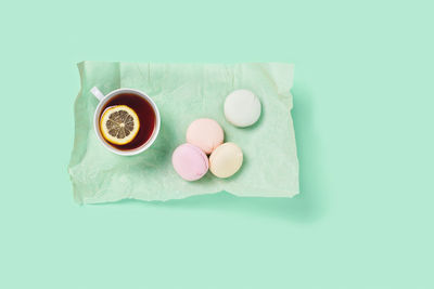 Food and drink mint concept. tea with lemon on a list of paper with marshmallows.