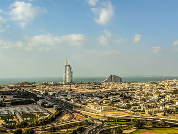 Aerial view of city buildings against cloudy sky