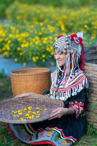 Midsection of woman holding flowers in basket