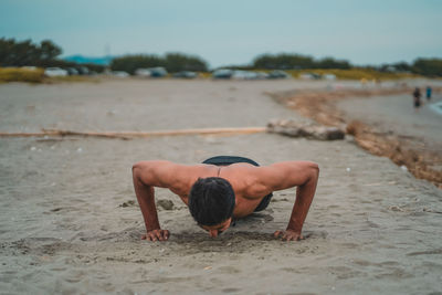 Rear view of shirtless man on beach