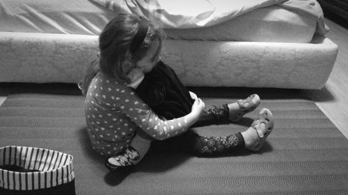 High angle view of girl sitting on sofa