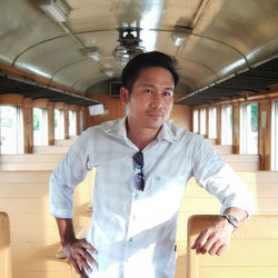 Portrait of man standing in train