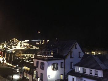 Illuminated buildings against sky at night