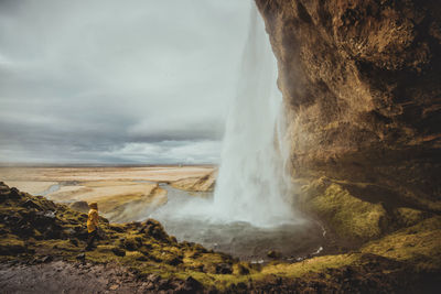 Man standing at waterfall