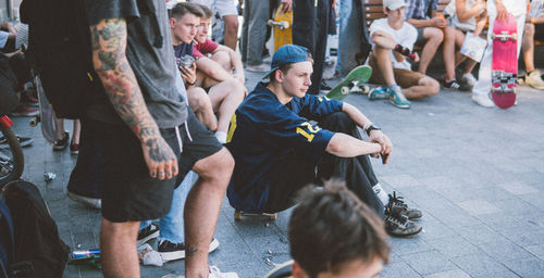 People sitting on street in city