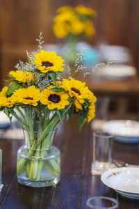 Close-up of yellow flowers in glass vase