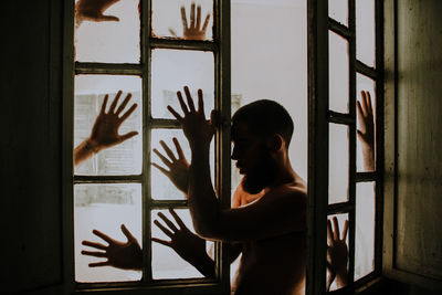 Side view of silhouette woman standing by window